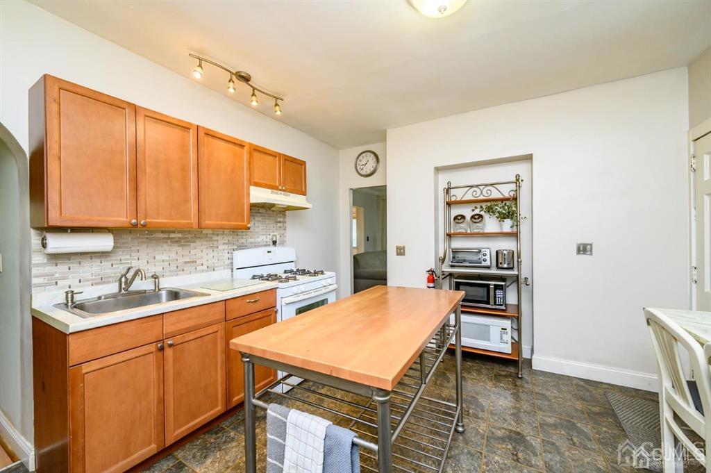 105 New Market Road Dunellen, NJ 08812 - Photo 5 of 39 a kitchen with a sink stove and cabinets