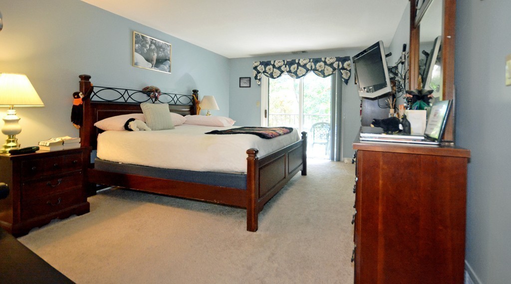 9 Ledgewood Way, Unit 2 Peabody, MA 01960 - Photo 11 of 22 a bed sitting in a bedroom next to a window