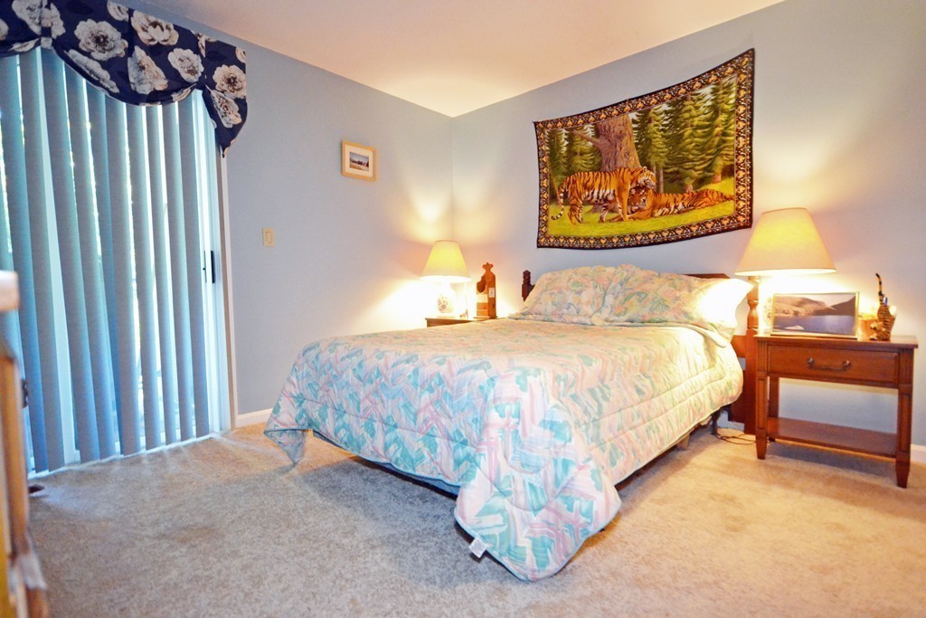 9 Ledgewood Way, Unit 2 Peabody, MA 01960 - Photo 13 of 22 a bedroom with a bed and a painting on the wall