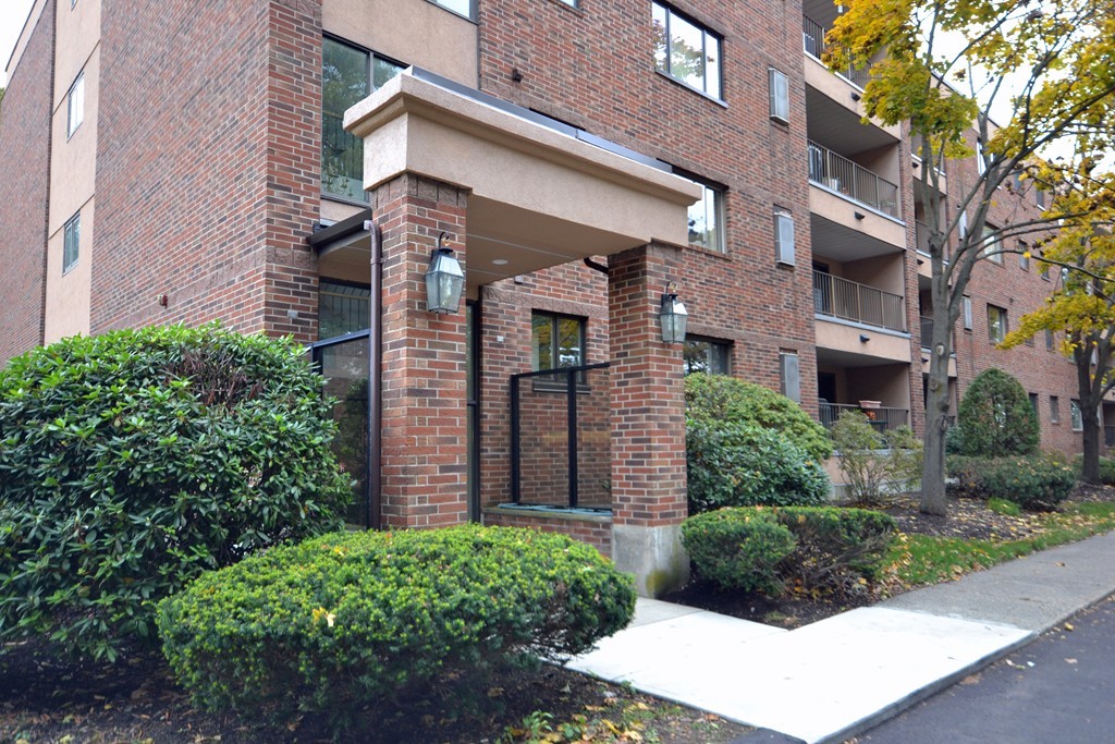 9 Ledgewood Way, Unit 2 Peabody, MA 01960 - Photo 2 of 22 a view of a brick building next to a yard