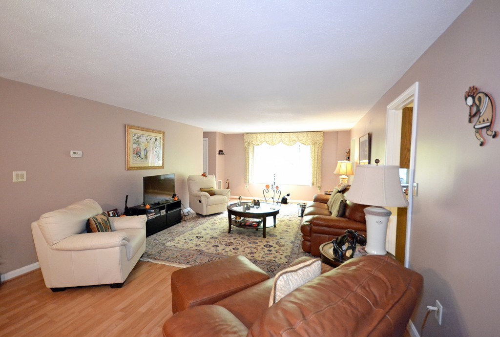 9 Ledgewood Way, Unit 2 Peabody, MA 01960 - Photo 6 of 22 a living room with furniture and a wooden floor