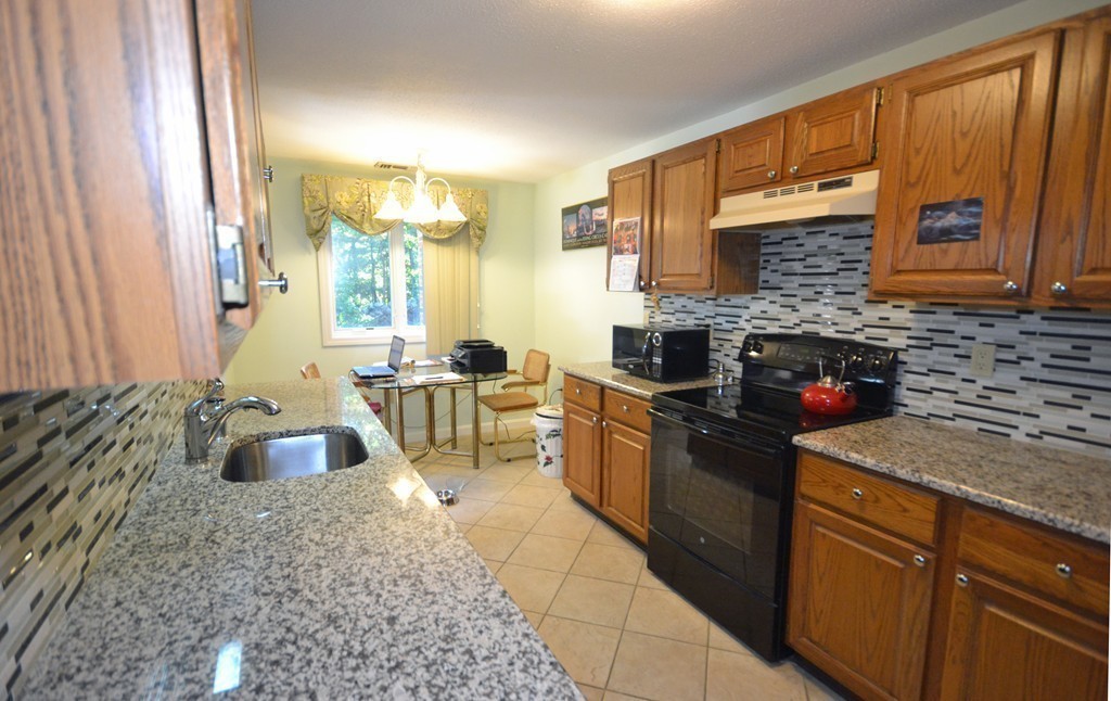 9 Ledgewood Way, Unit 2 Peabody, MA 01960 - Photo 8 of 22 a kitchen with a stove a sink and a microwave