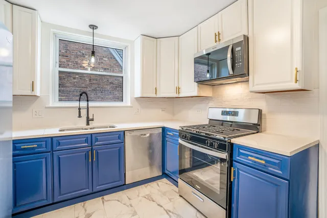 a kitchen with stainless steel appliances a stove microwave and sink