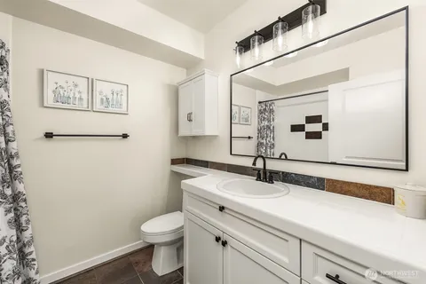 a bathroom with a sink a toilet and mirror
