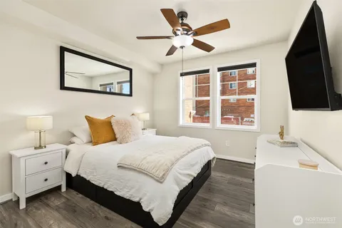 a bedroom with a large bed and a flat tv screen on dresser