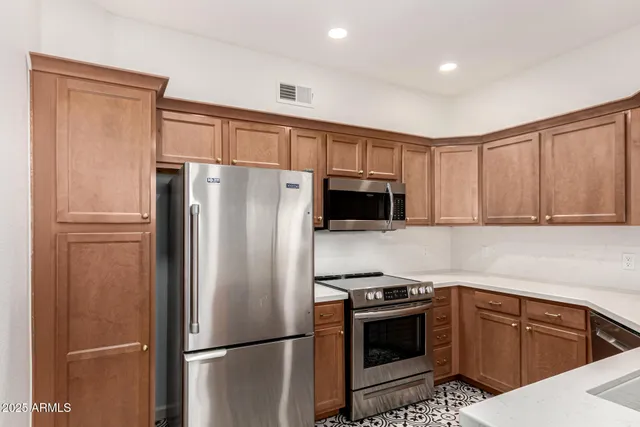 a kitchen with stainless steel appliances granite countertop a sink a stove a microwave oven with cabinets and wooden floor