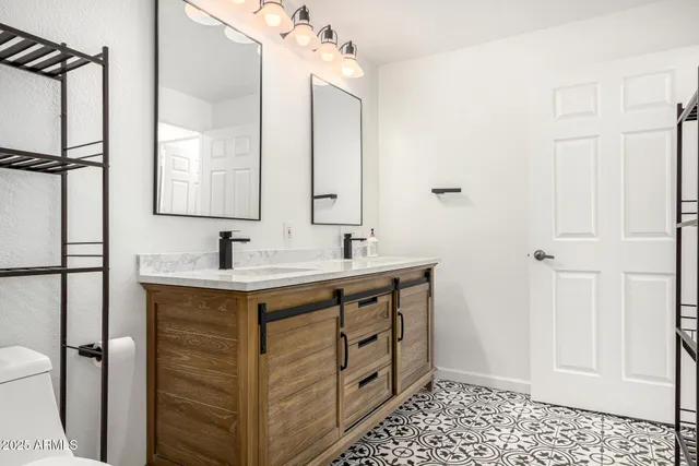 a spacious bathroom with a double vanity sink toilet mirror and shower