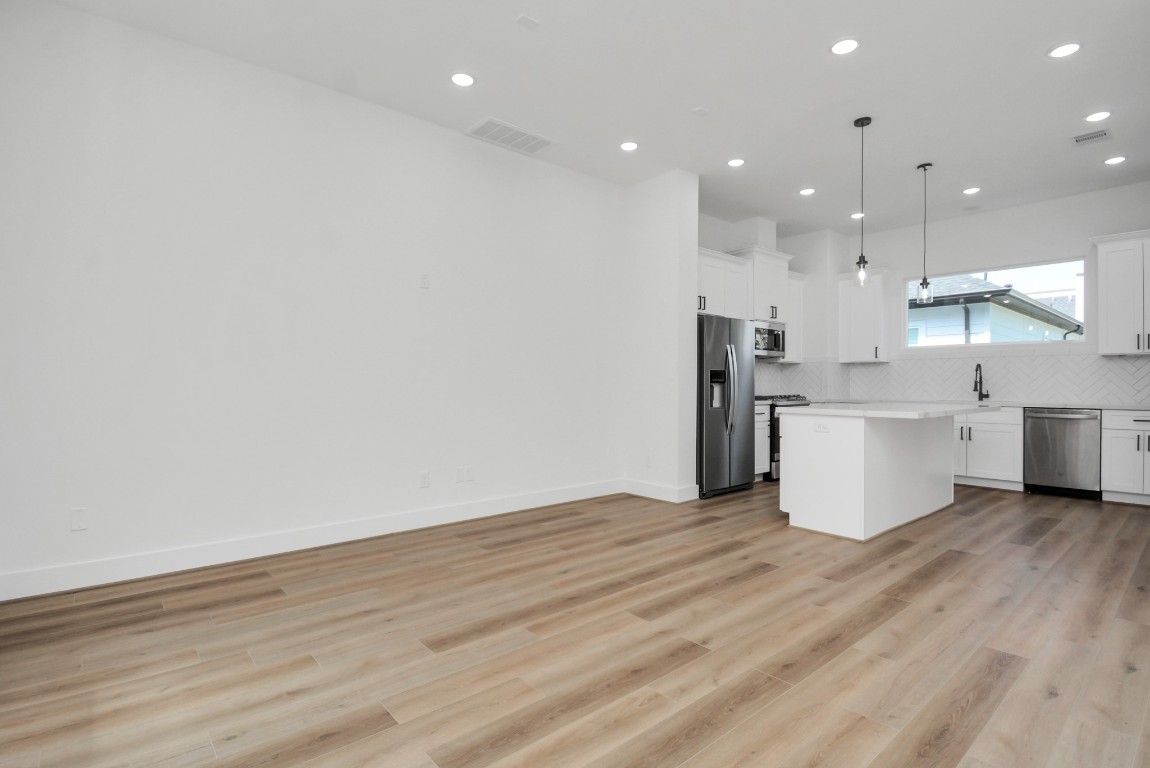 3036 Live Oak Street Houston, TX 77004 - Photo 14 of 35 a view of kitchen with kitchen island wooden floors and stainless steel appliances