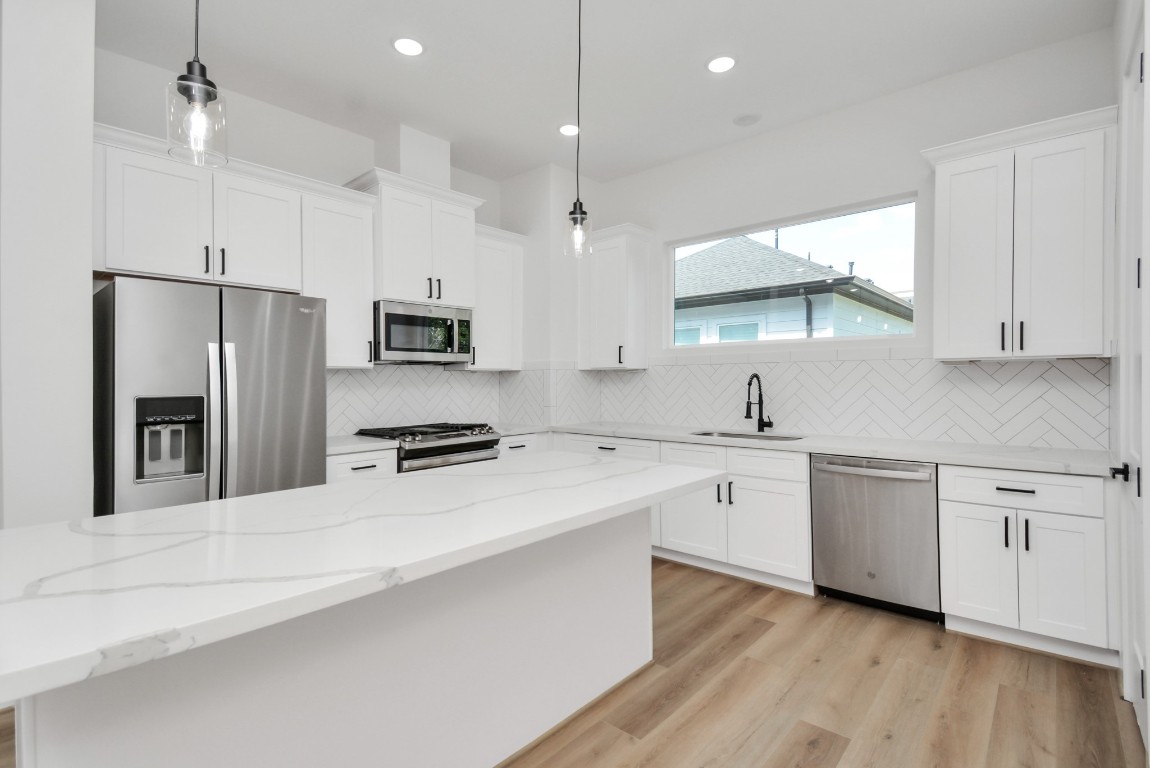 3036 Live Oak Street Houston, TX 77004 - Photo 16 of 35 a kitchen with white cabinets and stainless steel appliances