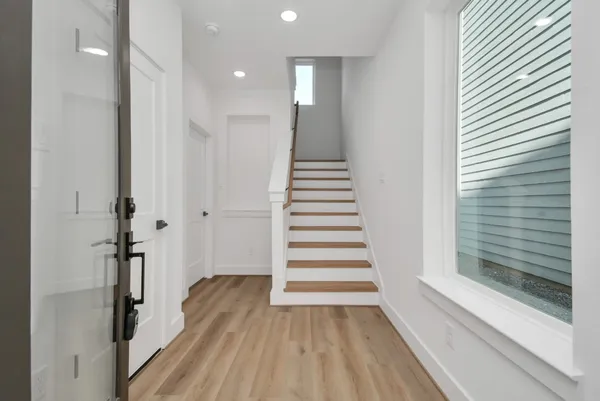 a view of a hallway with wooden floor and staircase