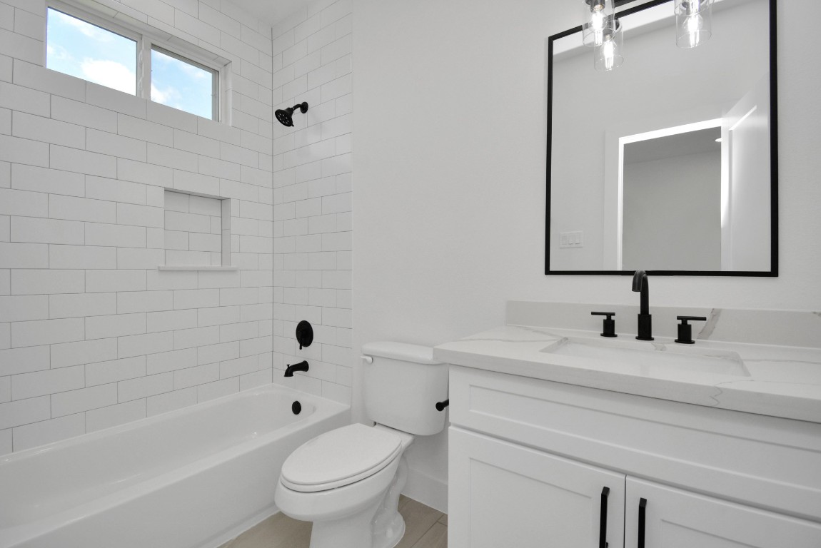 3036 Live Oak Street Houston, TX 77004 - Photo 31 of 35 a bathroom with a toilet a sink a mirror and bathtub