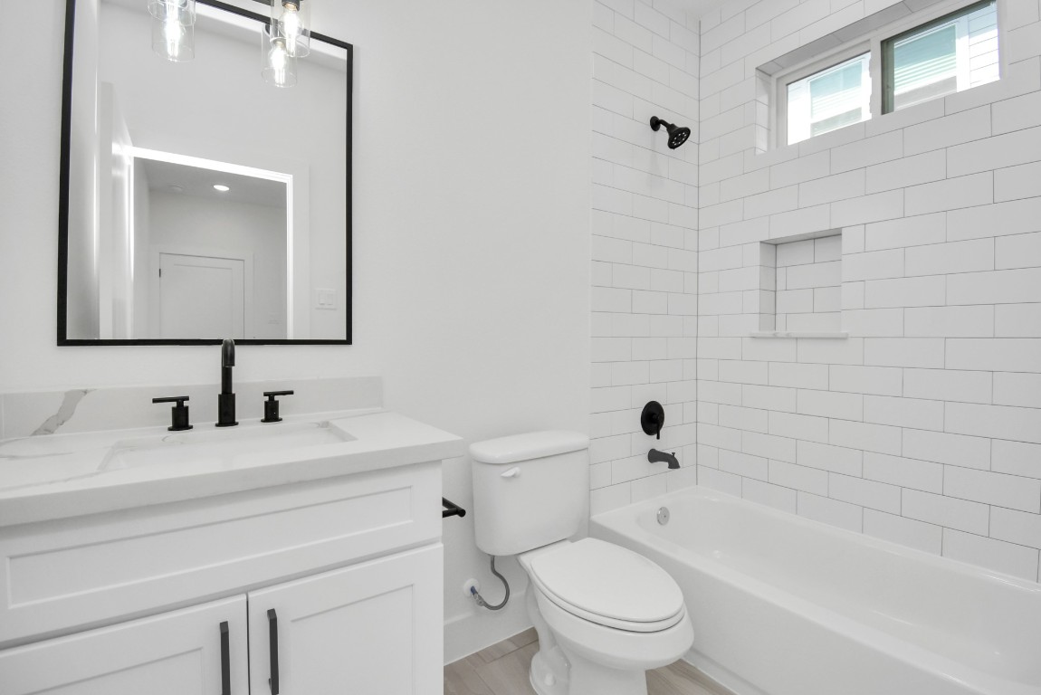 3036 Live Oak Street Houston, TX 77004 - Photo 7 of 35 a bathroom with a toilet a sink a mirror and bathtub