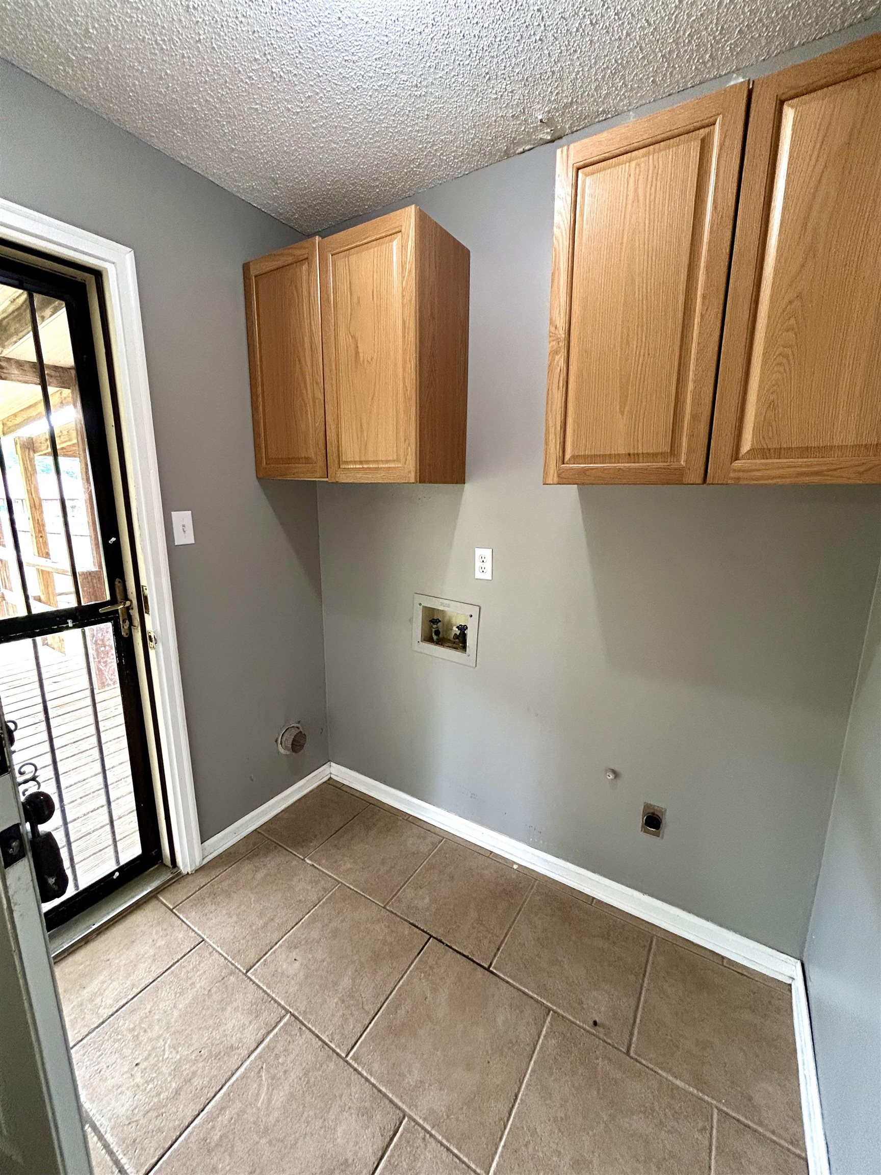 3257 Altruria Road Bartlett, TN 38134 - Photo 12 of 27 Laundry room with cabinet space, hookup for a washing machine, dark tile patterned flooring, electric dryer hookup, and plenty of natural light