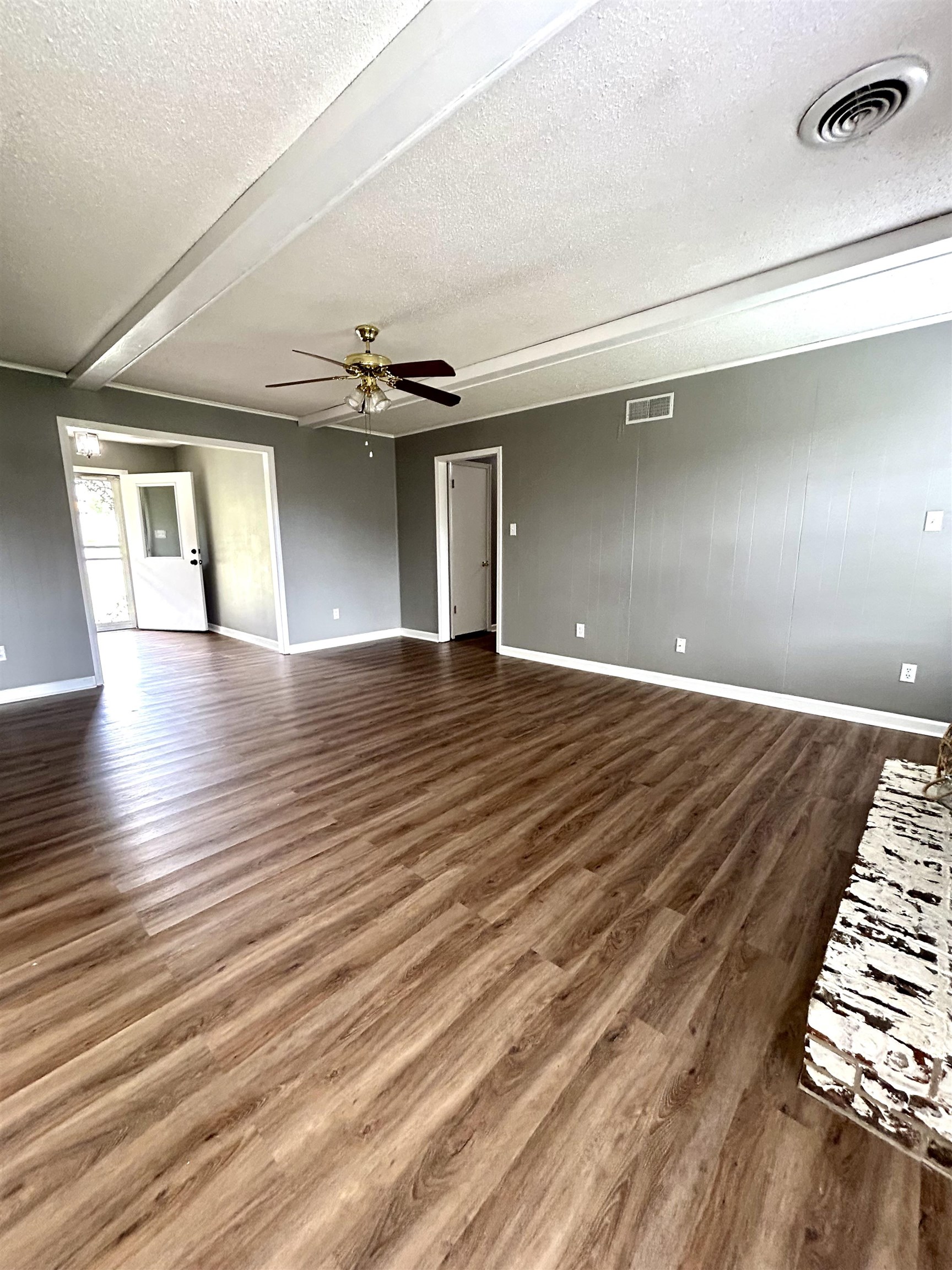 3257 Altruria Road Bartlett, TN 38134 - Photo 8 of 27 Unfurnished living room featuring wood finished floors, a textured ceiling, baseboards, and a ceiling fan