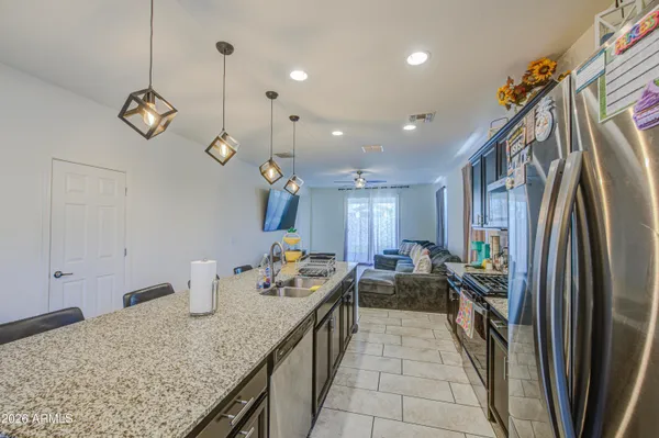 a kitchen with stainless steel appliances granite countertop a stove a refrigerator and a sink