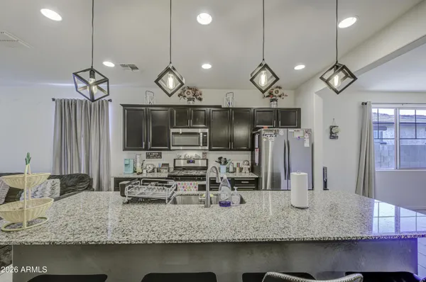 a kitchen with stainless steel appliances granite countertop a sink a stove and a refrigerator