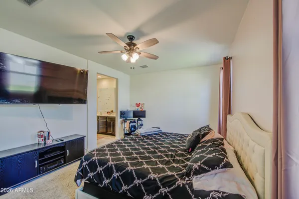 a bedroom with a bed and a flat tv screen on the dresser
