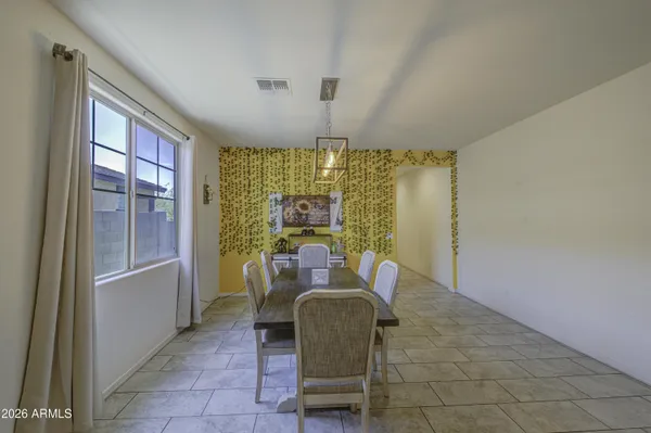 a dining room with furniture a chandelier and wooden floor