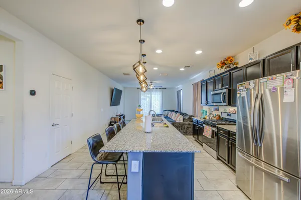 a kitchen with stainless steel appliances a dining table and chairs