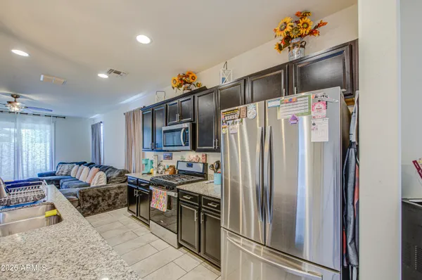 a kitchen with stainless steel appliances granite countertop a refrigerator and a stove