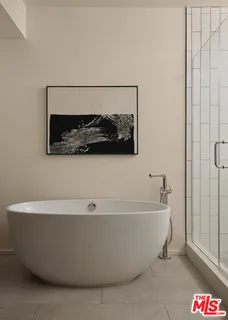 a white tub sitting next to a shower