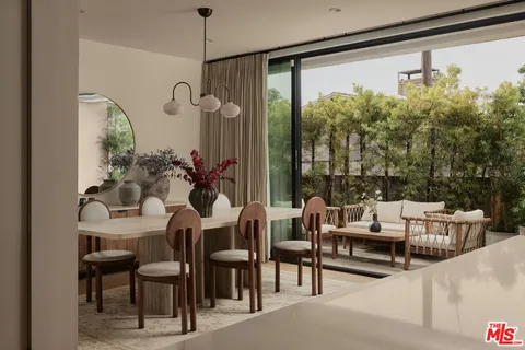 a dining room with furniture and a floor to ceiling window