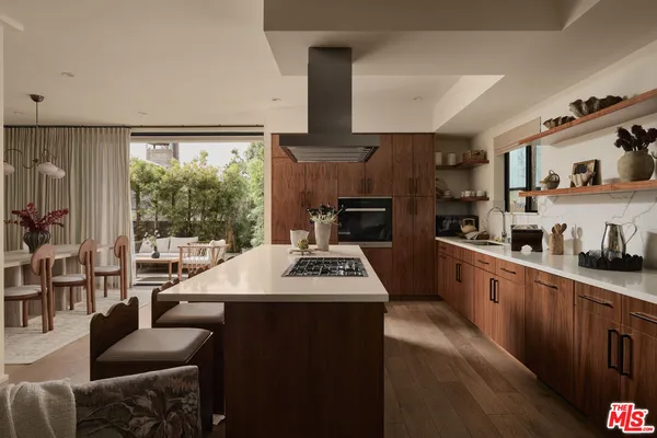 a kitchen with kitchen island granite countertop a sink appliances cabinets and a counter top space