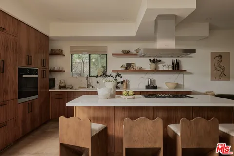 a kitchen with kitchen island granite countertop a sink stainless steel appliances and cabinets