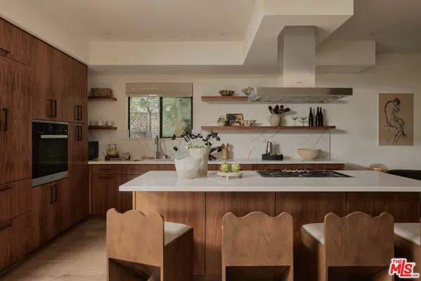 a kitchen with kitchen island granite countertop a sink stainless steel appliances and cabinets