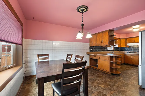 a kitchen with a refrigerator a stove cabinets and living room view