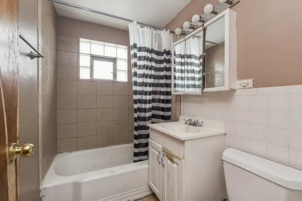 a bathroom with a sink toilet vanity and tub