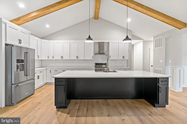 a kitchen with kitchen island a sink stainless steel appliances and cabinets