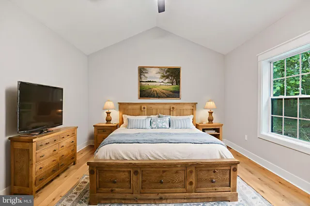 a bedroom with bed tv and window