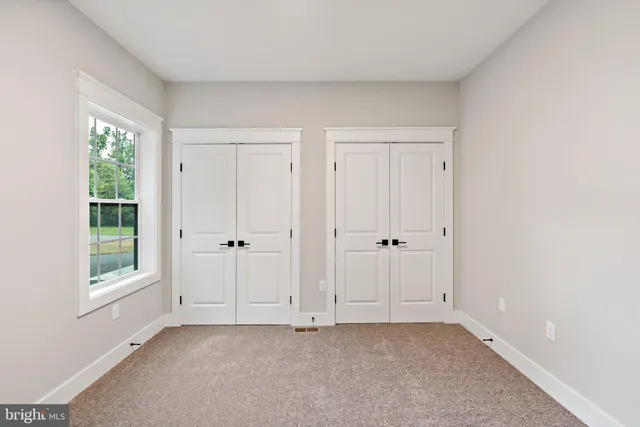 an empty room with windows and closet