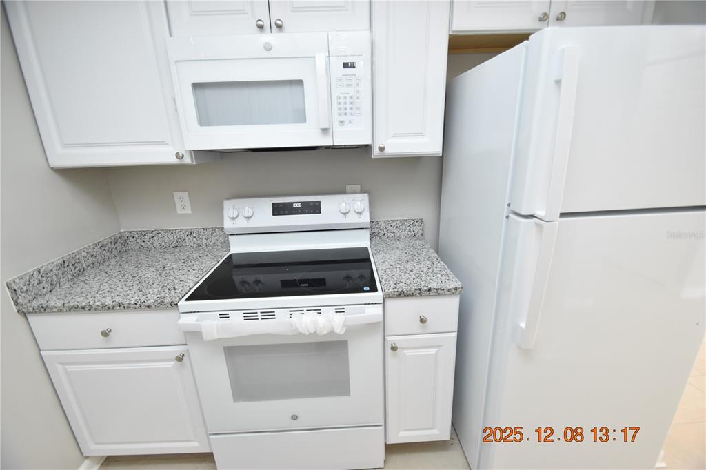 705 2nd Avenue Northwest, Unit B Ruskin, FL 33570 - Photo 12 of 29 a kitchen with granite countertop white cabinets and white appliances