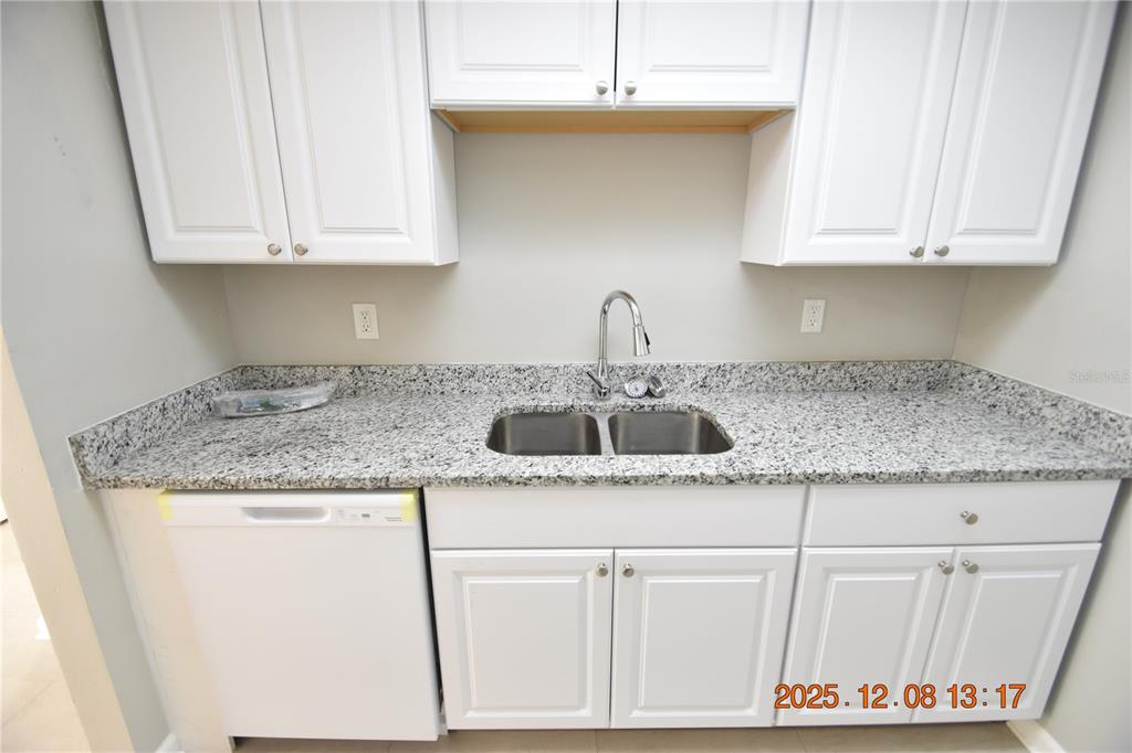 705 2nd Avenue Northwest, Unit B Ruskin, FL 33570 - Photo 13 of 29 a kitchen with granite countertop white cabinets and a sink