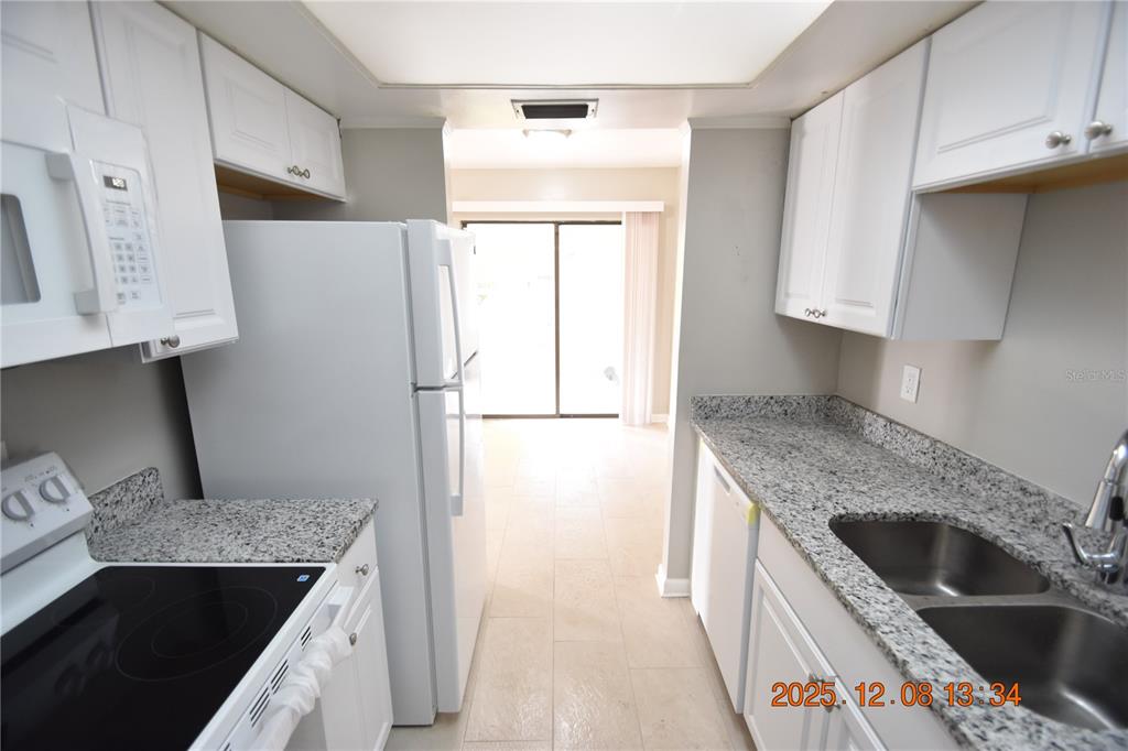 705 2nd Avenue Northwest, Unit B Ruskin, FL 33570 - Photo 21 of 29 a kitchen with granite countertop a sink stove and refrigerator