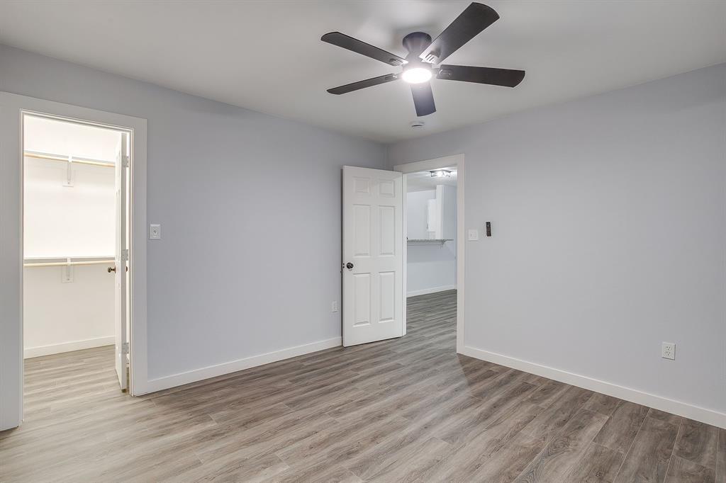 122 Kentucky Street Walnut Springs, TX 76690 - Photo 13 of 18 an empty room with wooden floor and ceiling fan