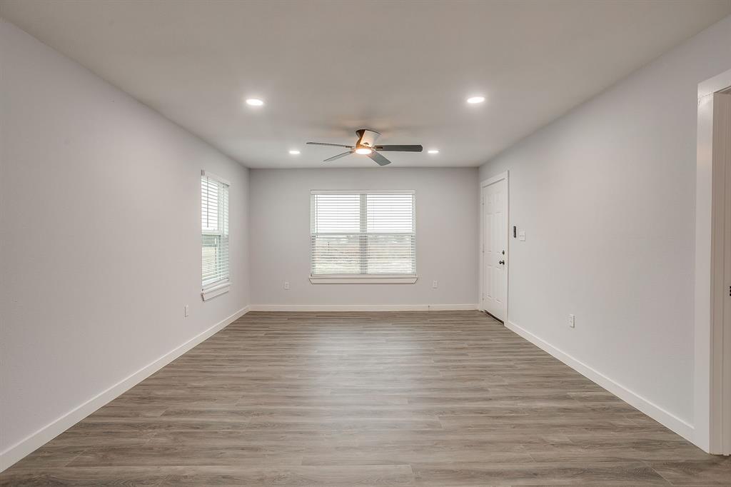 122 Kentucky Street Walnut Springs, TX 76690 - Photo 3 of 18 wooden floor in an empty room with a window