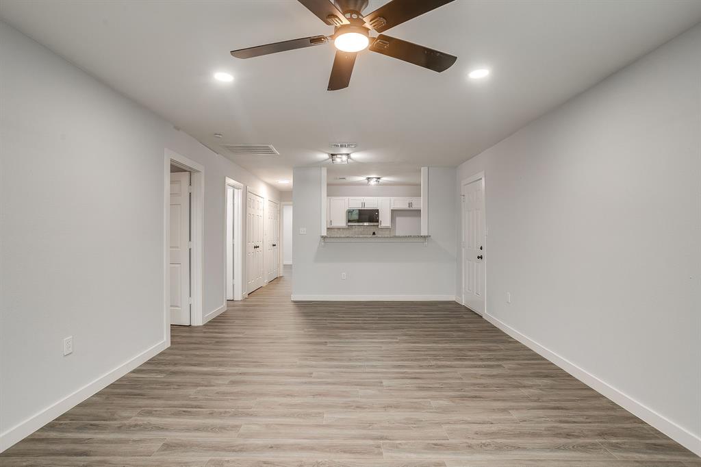 122 Kentucky Street Walnut Springs, TX 76690 - Photo 5 of 18 a view of a livingroom with a ceiling fan wooden floor and a ceiling fan