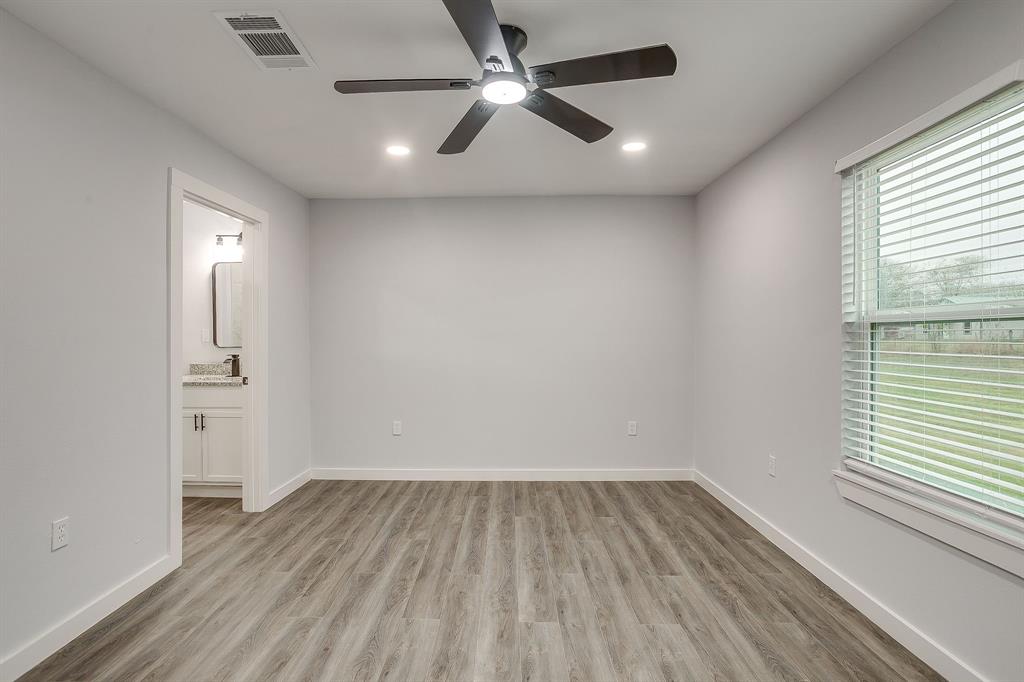 122 Kentucky Street Walnut Springs, TX 76690 - Photo 10 of 18 wooden floor in an empty room with a window