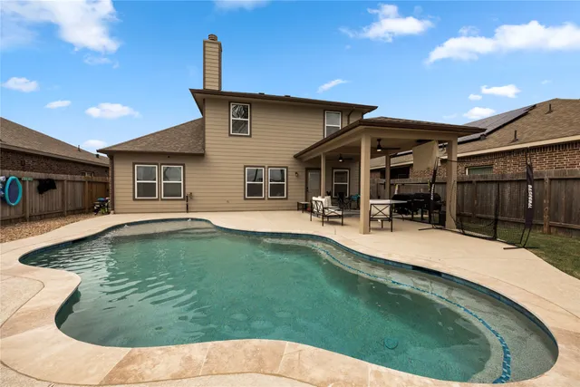 a swimming pool with outdoor seating and yard