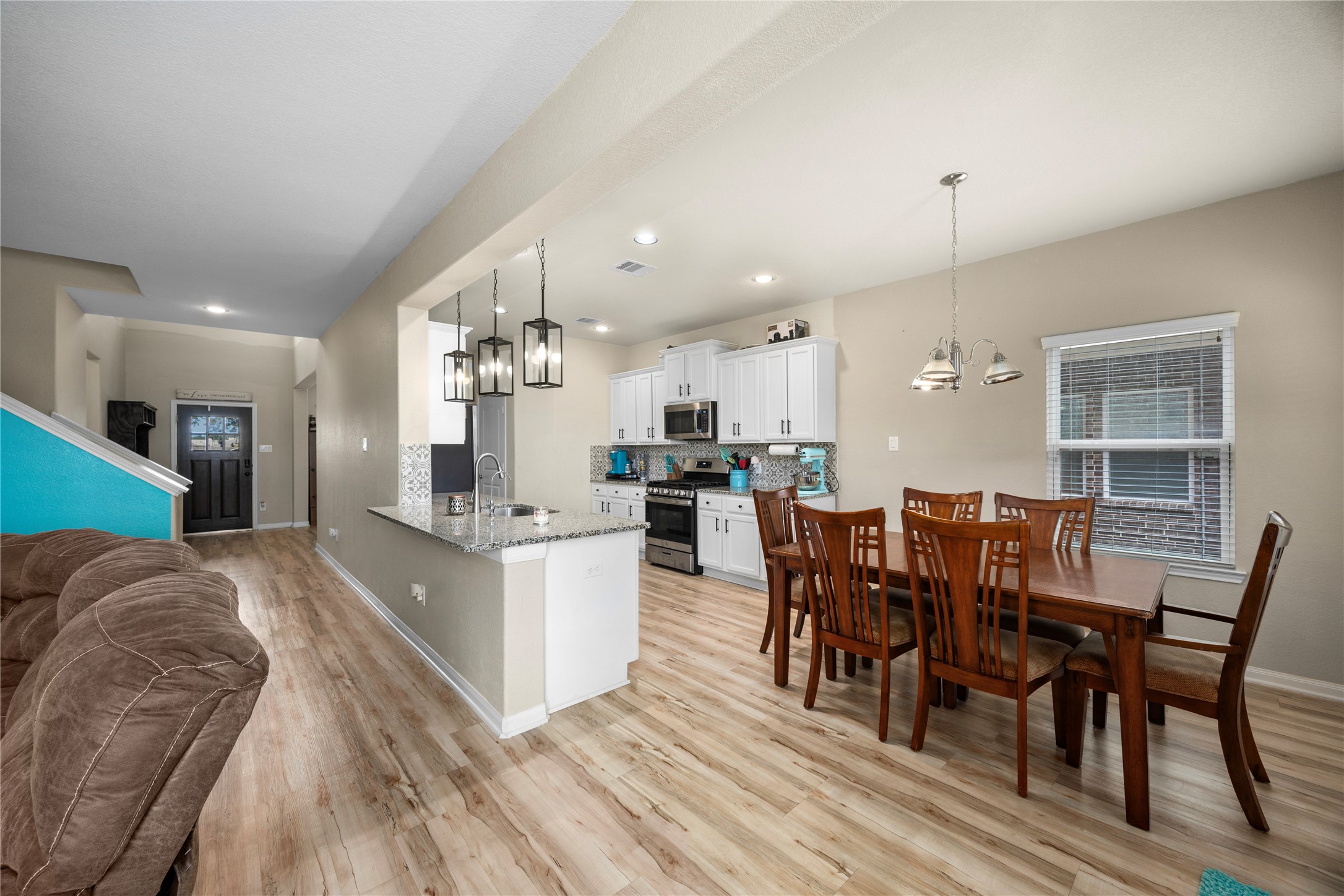 20272 Torrey Pines Lane Cleveland, TX 77327 - Photo 17 of 34 a large kitchen with stainless steel appliances granite countertop a dining table chairs and granite counter tops