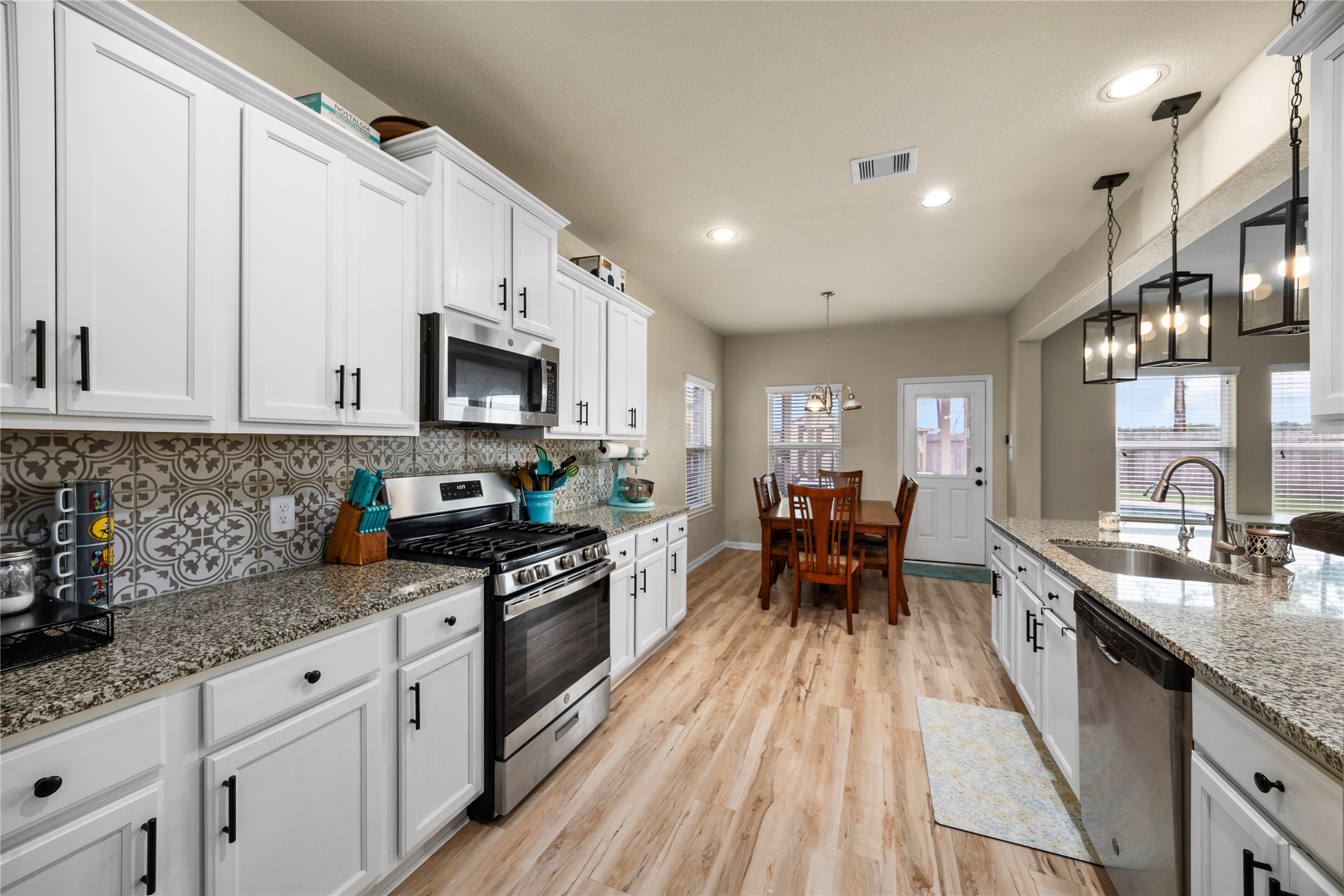 20272 Torrey Pines Lane Cleveland, TX 77327 - Photo 19 of 34 a kitchen with granite countertop a sink stove and cabinets