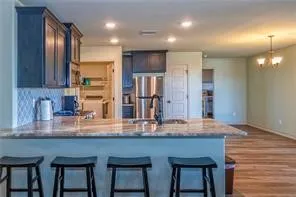 a kitchen with kitchen island granite countertop wooden cabinets and refrigerator