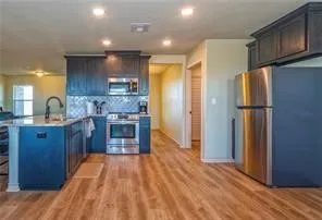 a kitchen with stainless steel appliances granite countertop a refrigerator a sink and a stove