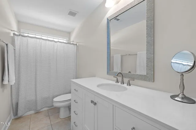 a bathroom with a sink a toilet a mirror and shower