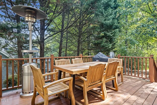 a view of deck with patio table and chairs with wooden floor and fence