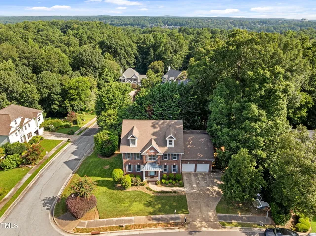 an aerial view of a house with a garden and lake view