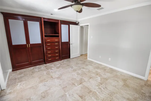 en empty room with windows and ceiling fan